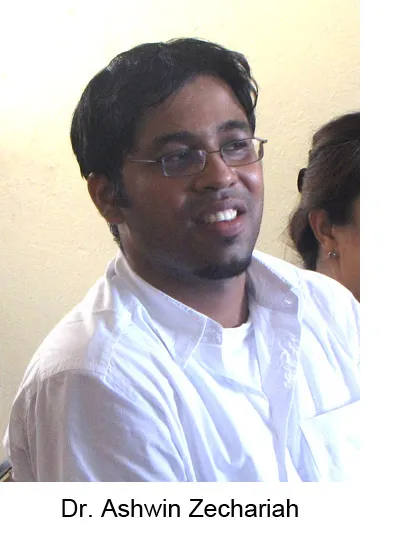 Dr. Ashwin Zechariah, wearing glasses and a white shirt, seated indoors with a slight smile.
